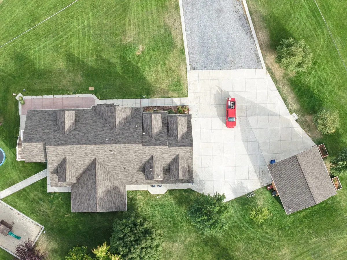 Drone view of a completed roof replacement on a home and garage