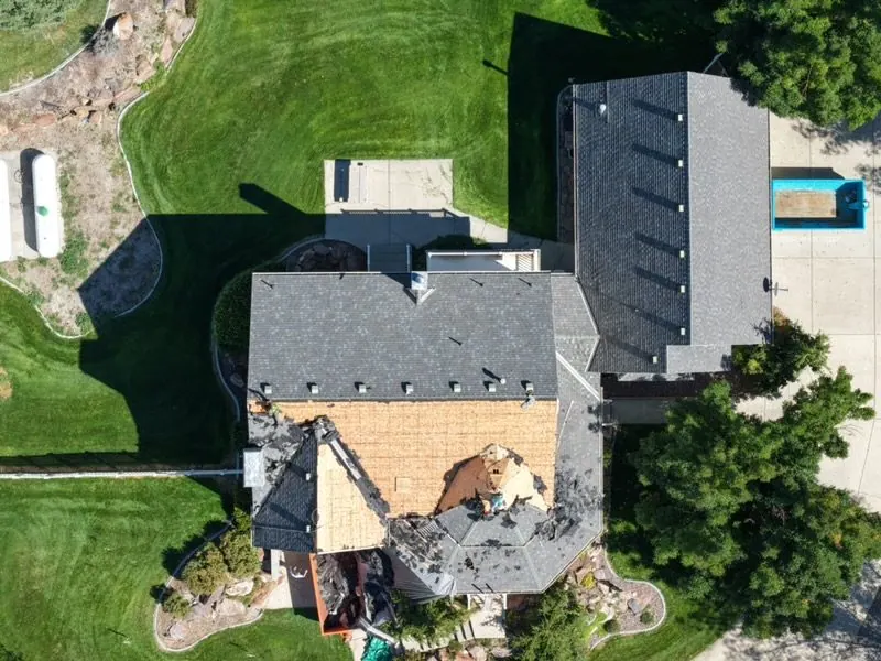 Drone view of roof tear-off in progress on a home
