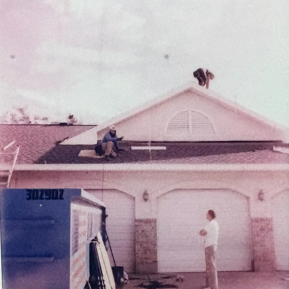 Polaroid of the White Pine crew working on a garage roof